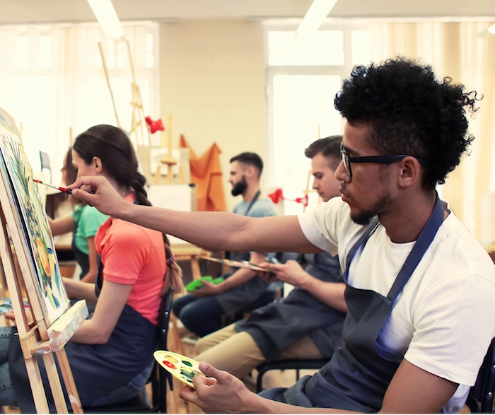 Young People Painting At Easel