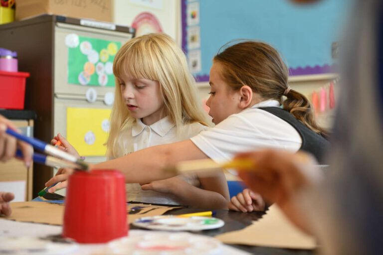 Two primary school children painting